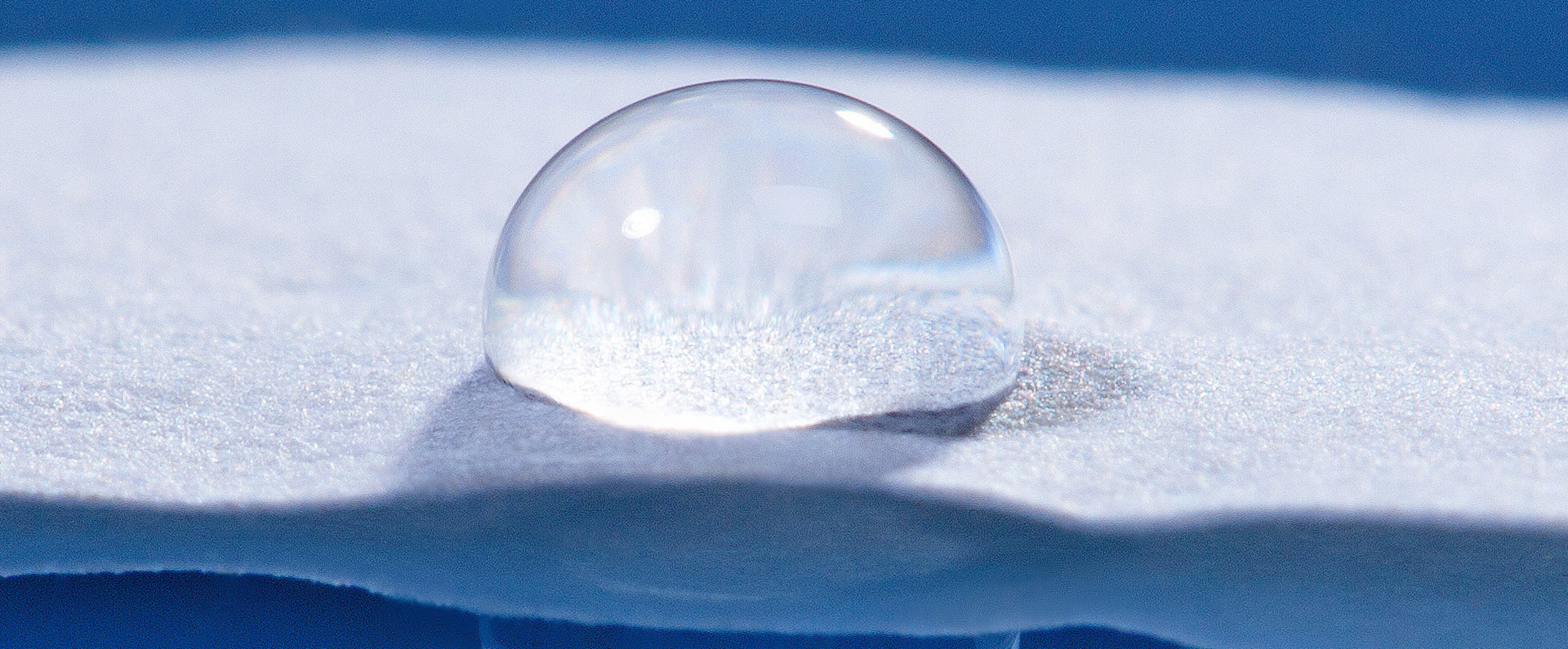 A drop of water on paper with water resistant starch-based coating.