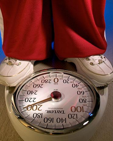 D444-1 Someone standing on a scale weighing themselves