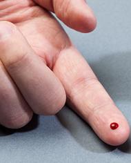 A hand with a drop of blood on the index finger