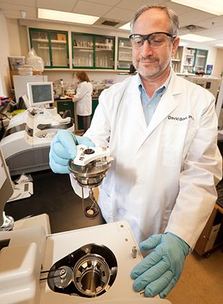 ARS physiologist David Baer holding a diet study sample in the laboratory