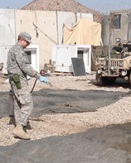 U.S. Army medical entomologist applying a residual treatment of lambdacyhalothrin to camouflage netting and shade cloth 